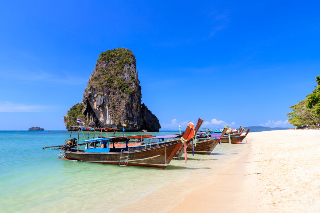 Long tail boat and turquoise crystal clear sea water with limest